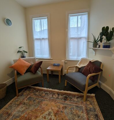 Two armchairs facing each other by tall windows